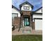 Stylish home entrance with stone accents and a charming turquoise door at 11699 Pink Phlox Dr, Parker, CO 80134