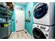 Well-lit laundry room with a stacked washer and dryer, shelving, and a charming 'Lost Socks' sign at 11699 Pink Phlox Dr, Parker, CO 80134