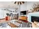 Inviting living room featuring stylish decor, fireplace, and seamless flow into the adjacent kitchen at 11699 Pink Phlox Dr, Parker, CO 80134