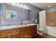 Bathroom featuring a dual sink vanity, granite countertops, and a shower-tub combination at 9461 Ashbury Cir # 104, Parker, CO 80134