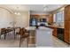 Well-lit kitchen features a breakfast bar, wood cabinetry, and black appliances next to a dining area at 9461 Ashbury Cir # 104, Parker, CO 80134