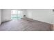 Large living room with neutral carpet, bright natural light, and view of an outdoor balcony at 9340 E Center Ave # 8B, Denver, CO 80247