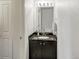 Bathroom showcasing a black vanity with granite countertop, vanity lights, and a large mirror at 9102 W 107Th Pl, Broomfield, CO 80021
