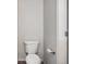 Neutral-toned bathroom featuring a standard white toilet next to a white door and gray walls at 9102 W 107Th Pl, Broomfield, CO 80021