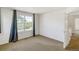 Bedroom with a large window with dark curtains and a door on the side at 9102 W 107Th Pl, Broomfield, CO 80021