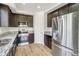 Updated kitchen featuring granite countertops, stainless steel appliances, and dark wood cabinets at 9102 W 107Th Pl, Broomfield, CO 80021