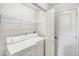 Functional laundry room featuring a washer, dryer, storage shelving, and a utility sink at 9102 W 107Th Pl, Broomfield, CO 80021