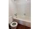 Bright bathroom with a white tiled shower and an open toilet with the seat up at 10650 E Tennessee Ave # 101, Aurora, CO 80012