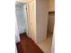 Bathroom and closet featuring hardwood floor, white tile, and white walls at 10650 E Tennessee Ave # 101, Aurora, CO 80012