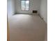 Bedroom with neutral carpet, white walls, window, and wall-mounted unit at 10650 E Tennessee Ave # 101, Aurora, CO 80012