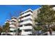 A modern condo building with balconies and well-maintained landscaping on a bright, sunny day at 10650 E Tennessee Ave # 101, Aurora, CO 80012