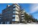 Apartment building featuring balconies and adjacent parking spaces on a partly cloudy day at 10650 E Tennessee Ave # 101, Aurora, CO 80012