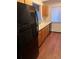 Kitchen with modern appliances, wood flooring, wooden cabinets, and stainless steel sink under window at 10650 E Tennessee Ave # 101, Aurora, CO 80012