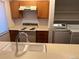 Kitchen featuring stove, overhead vent, and a view of washer and dryer units at 10650 E Tennessee Ave # 101, Aurora, CO 80012