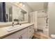 Bright bathroom featuring a vanity with lots of storage and shower-tub combo at 7418 S Quail Cir, Littleton, CO 80127