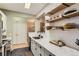 Bright kitchen featuring white cabinets, marble countertops, open shelving, and stainless steel appliances at 7418 S Quail Cir, Littleton, CO 80127