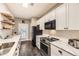 Well-lit kitchen featuring white cabinets, stainless steel appliances, modern countertops, and a stylish design at 7418 S Quail Cir, Littleton, CO 80127