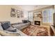 Cozy living room featuring a fireplace, plush sectional, and bright windows with shutter-style blinds at 7418 S Quail Cir, Littleton, CO 80127