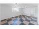 Basement area featuring neutral walls, monochrome checkered floors, and large windows for lots of light at 7845 Conifer Rd, Denver, CO 80221