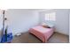 Comfortable bedroom with soft carpet, a bright window, and a neutral color scheme with modern lighting at 7845 Conifer Rd, Denver, CO 80221