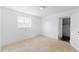 Bright bedroom features neutral carpeting, a large window, and a hallway entry at 7845 Conifer Rd, Denver, CO 80221