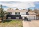 Two-story home with a black and white painted exterior, inviting entrance, and a spacious two-car garage at 7845 Conifer Rd, Denver, CO 80221