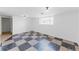 A spacious living room with checkered floors and white walls features natural light from the window at 7845 Conifer Rd, Denver, CO 80221