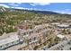 Lovely aerial view of a beautiful multi-unit property surrounded by mature landscaping, river, and mountain views at 100 S Park Ave # E312, Breckenridge, CO 80424