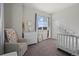 Bright Bedroom featuring a crib, dresser, neutral decor and natural light from the large window at 11250 Florence St # 28F, Commerce City, CO 80640