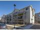 Modern condo building with multiple balconies and attractive landscaping under a blue sky at 11250 Florence St # 28F, Commerce City, CO 80640