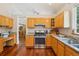 Functional kitchen featuring hardwood floors, granite countertops, and a stainless steel range and hood at 8095 Bannock Dr, Larkspur, CO 80118