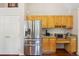Updated kitchen featuring a stainless steel refrigerator and custom wood cabinets, adjacent to a door at 8095 Bannock Dr, Larkspur, CO 80118