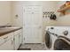 Well-equipped laundry room with sink, cabinets, shelving, and modern Samsung washer and dryer at 8095 Bannock Dr, Larkspur, CO 80118