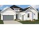 Exterior of two-story home with a gray garage door, stone landscaping, and craftsman-style accents at 901 Coal Bank Trl, Castle Rock, CO 80104