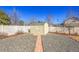 Backyard featuring a storage shed, white fence, rock area, and walkway at 9912 Bradbury St, Firestone, CO 80504