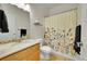 Bright bathroom featuring a floral-patterned shower curtain, a single sink vanity, and tiled floors at 9912 Bradbury St, Firestone, CO 80504