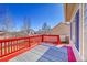 Bright red painted outdoor deck with stylish outdoor rug and railing at 9912 Bradbury St, Firestone, CO 80504