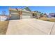 Home featuring a long driveway leading to a two-car garage with stone accents and manicured lawn at 9912 Bradbury St, Firestone, CO 80504