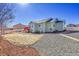 Exterior view of a home with a red deck, rock yard, and green grass area at 9912 Bradbury St, Firestone, CO 80504