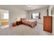 Cozy main bedroom features carpet flooring, a window, and an ensuite bathroom for optimal comfort and convenience at 9912 Bradbury St, Firestone, CO 80504