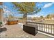 Enjoy this patio with a hot tub, large tree, and black metal fence and play area in the background at 10843 W Hinsdale Dr, Littleton, CO 80127