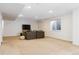 Finished basement space with neutral carpet and walls, including a television and cozy seating at 10843 W Hinsdale Dr, Littleton, CO 80127