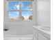 Bright bathroom with a soaking tub and a large window offering ample natural light at 10843 W Hinsdale Dr, Littleton, CO 80127