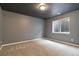 Empty room with neutral carpet, dark gray ceiling, and a basement window at 10843 W Hinsdale Dr, Littleton, CO 80127