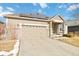 Charming front exterior featuring a two-car garage, solar panels, and a covered entry with brick pillars at 10843 W Hinsdale Dr, Littleton, CO 80127