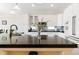 Modern kitchen with white cabinets, stainless steel appliances, and a sleek black countertop island at 10843 W Hinsdale Dr, Littleton, CO 80127