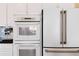 White kitchen appliances, including oven, microwave, and stainless steel refrigerator at 10843 W Hinsdale Dr, Littleton, CO 80127