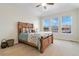 Vaulted primary bedroom with a decorative wood bed and a large window view at 10843 W Hinsdale Dr, Littleton, CO 80127