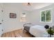 Cozy bedroom with hardwood floors, a large window providing natural light, and minimalist decor at 902 Poplar St, Denver, CO 80220