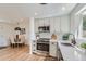 Modern kitchen with stainless steel appliances, white cabinets, and view into dining area at 902 Poplar St, Denver, CO 80220